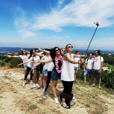 Ragazzi e ragazze si scattano un selfie. Sono un gruppo sulle colline delle Langhe